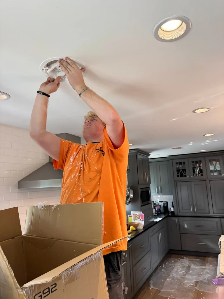 image of person fixing electrical equipment on roof